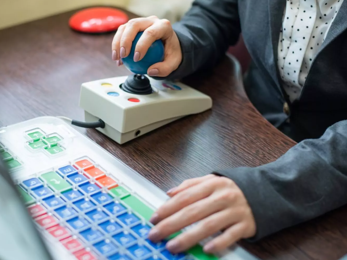 Woman with cerebral palsy works on a specialized computer mouse.